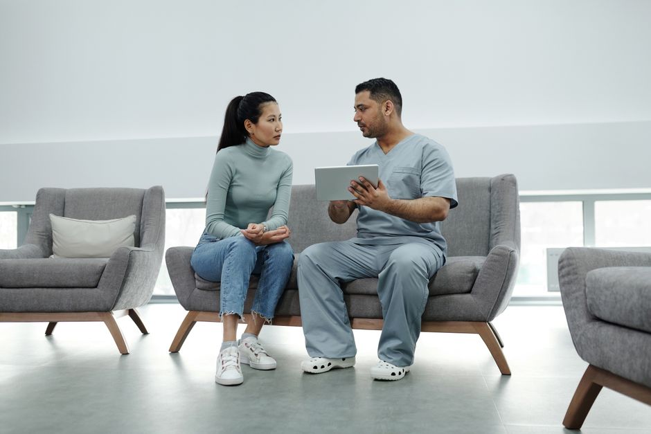 A clinician reviewing information with a patient in a calm, bright waiting area