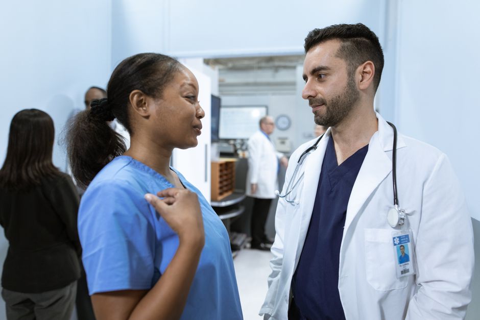 A doctor and a nurse talking in a hospital corridor